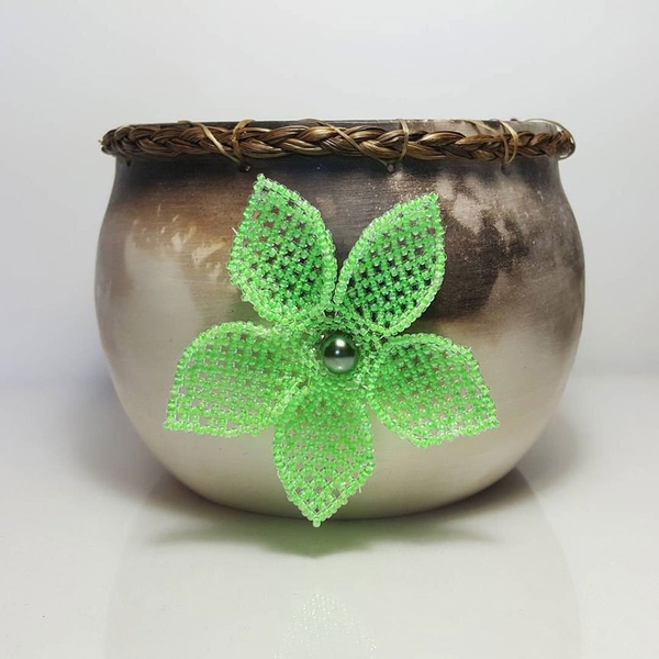 Pot en céramique décoré de foin d’odeur tressé et d’une fleur perlée.